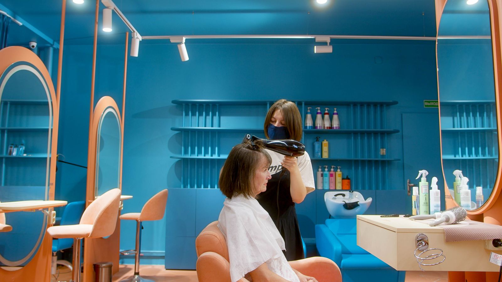Stylist serving a client in a bright independent salon